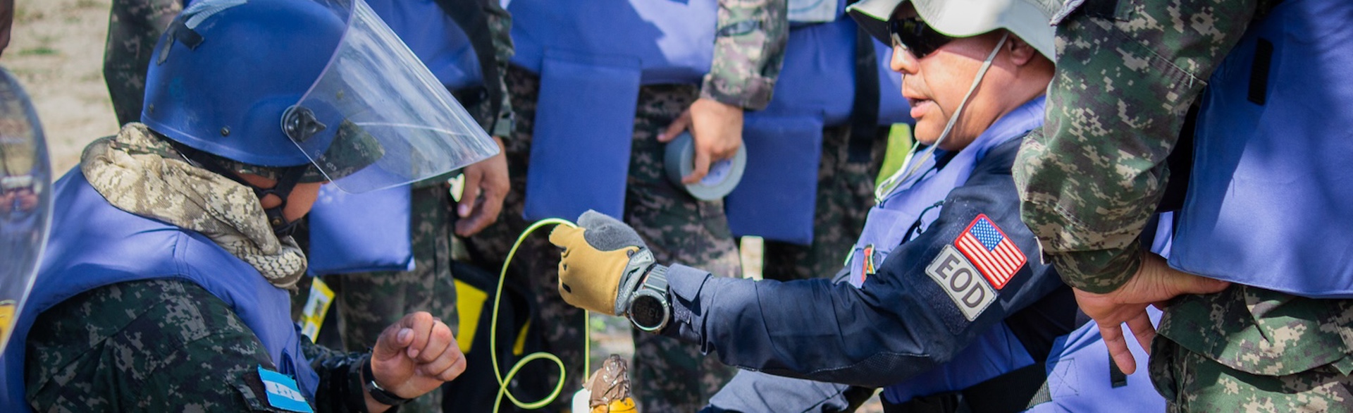 Deminers wearing PPE take on a practical explosive ordnance disposal course