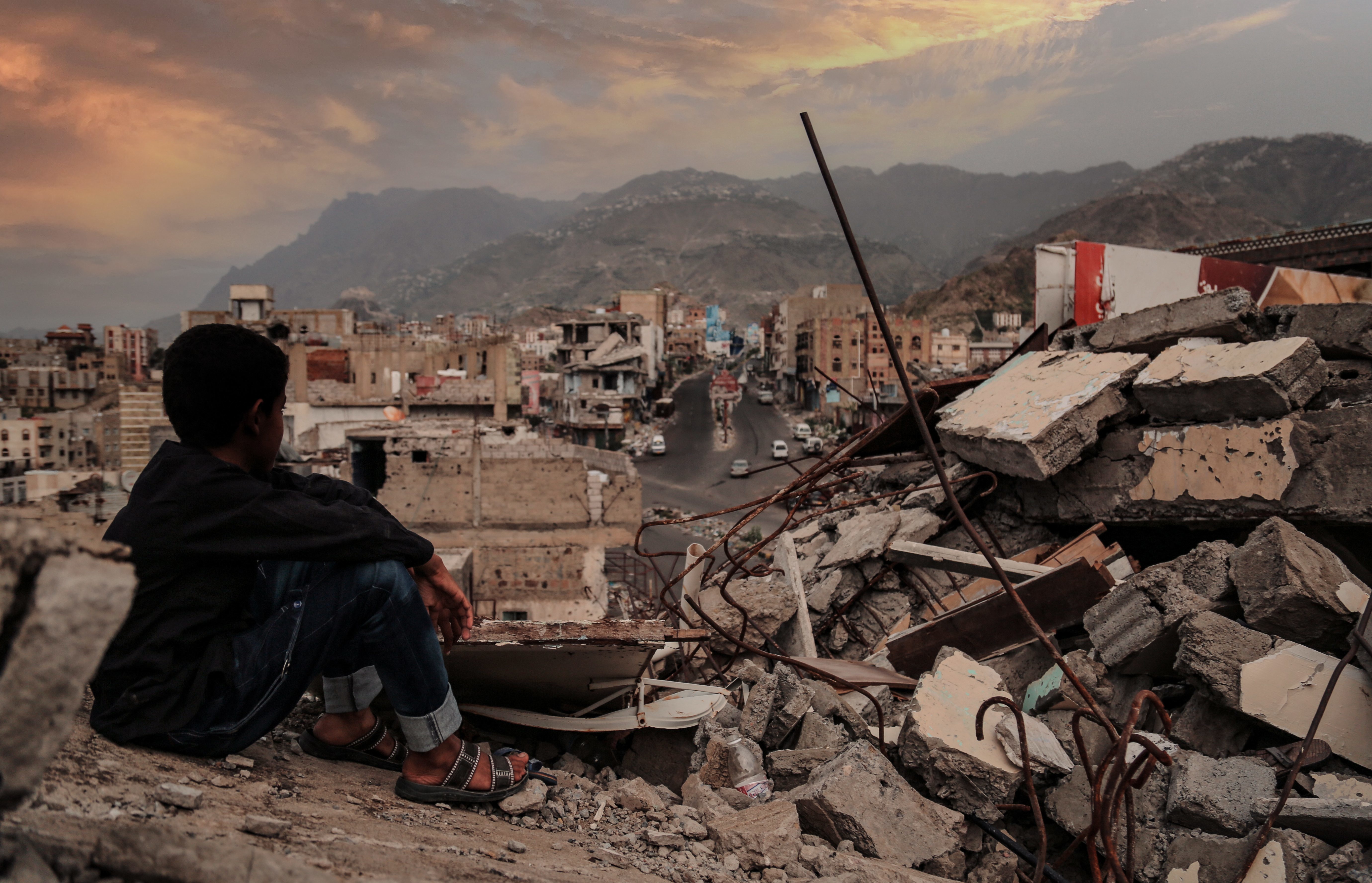 Young boy looks across the ruins of a Yemeni city