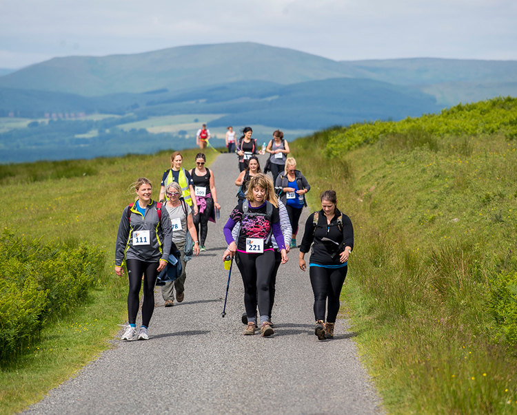 A group participating in the "walk for Syria" event walk through a path in the countryside