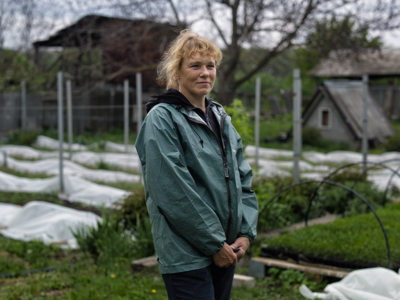 Наталя навпроти теплиць на фермі