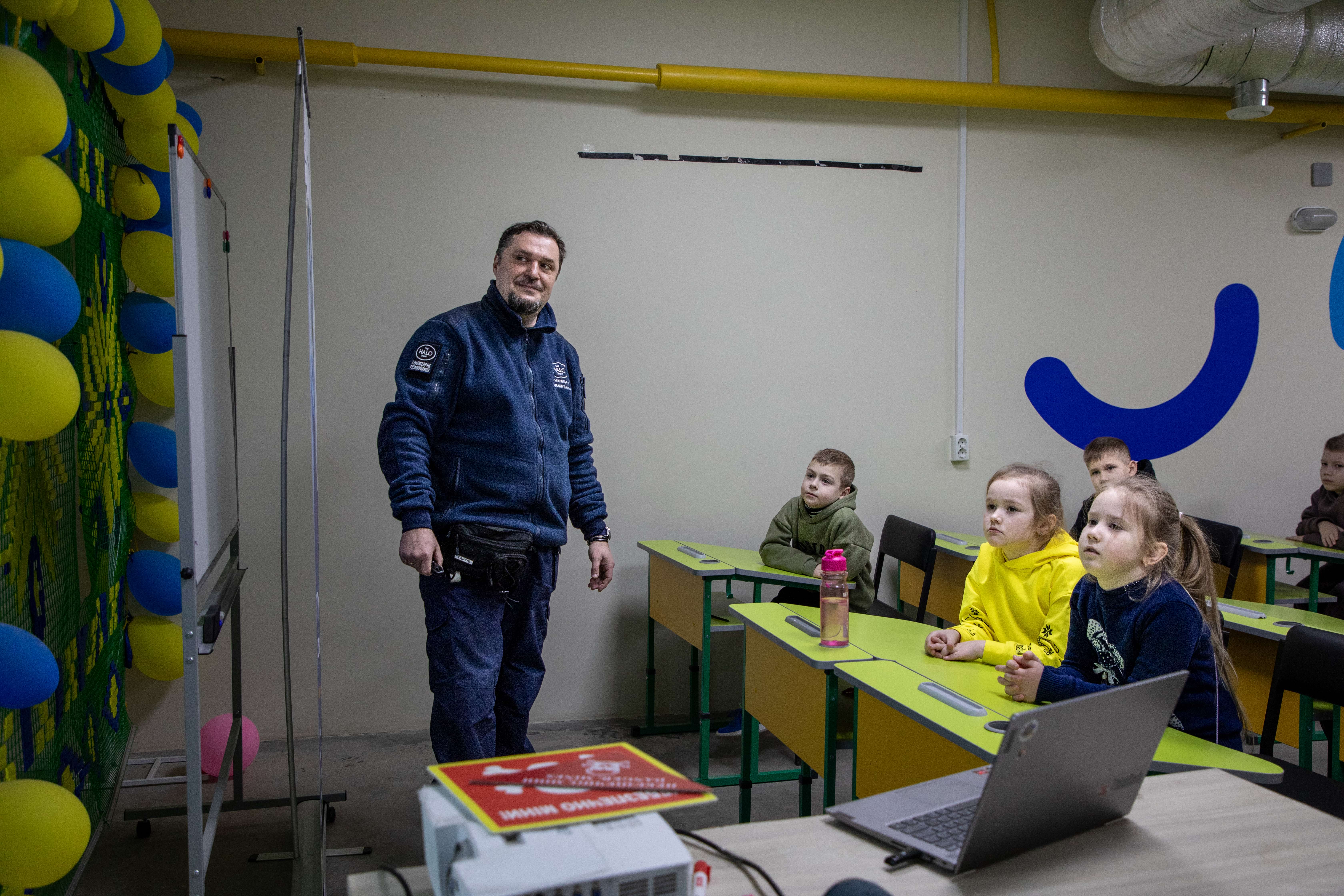 Спеціаліст х мінної просвіти навчає дітей безпечній поведінці при зустрічі з мінами