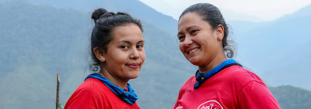 Two women in HALO T-shirts smile outside