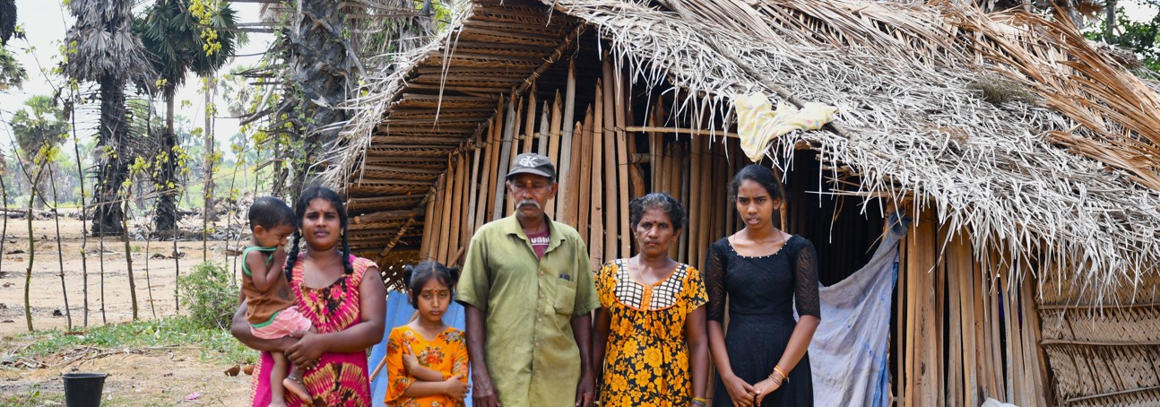 A family stands in front of their home.