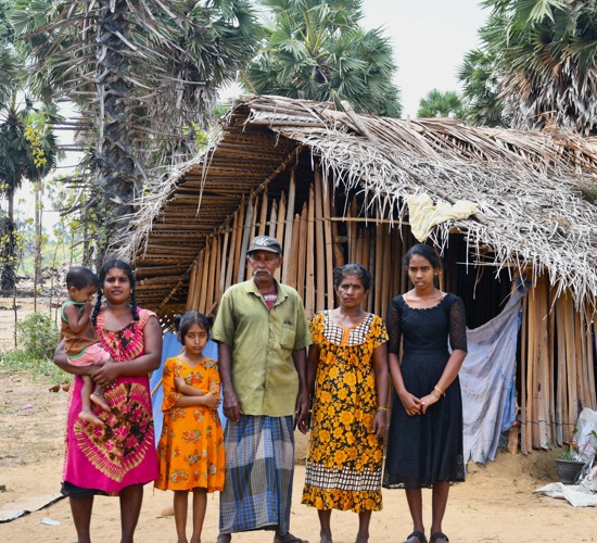 A family stands in front of their home.