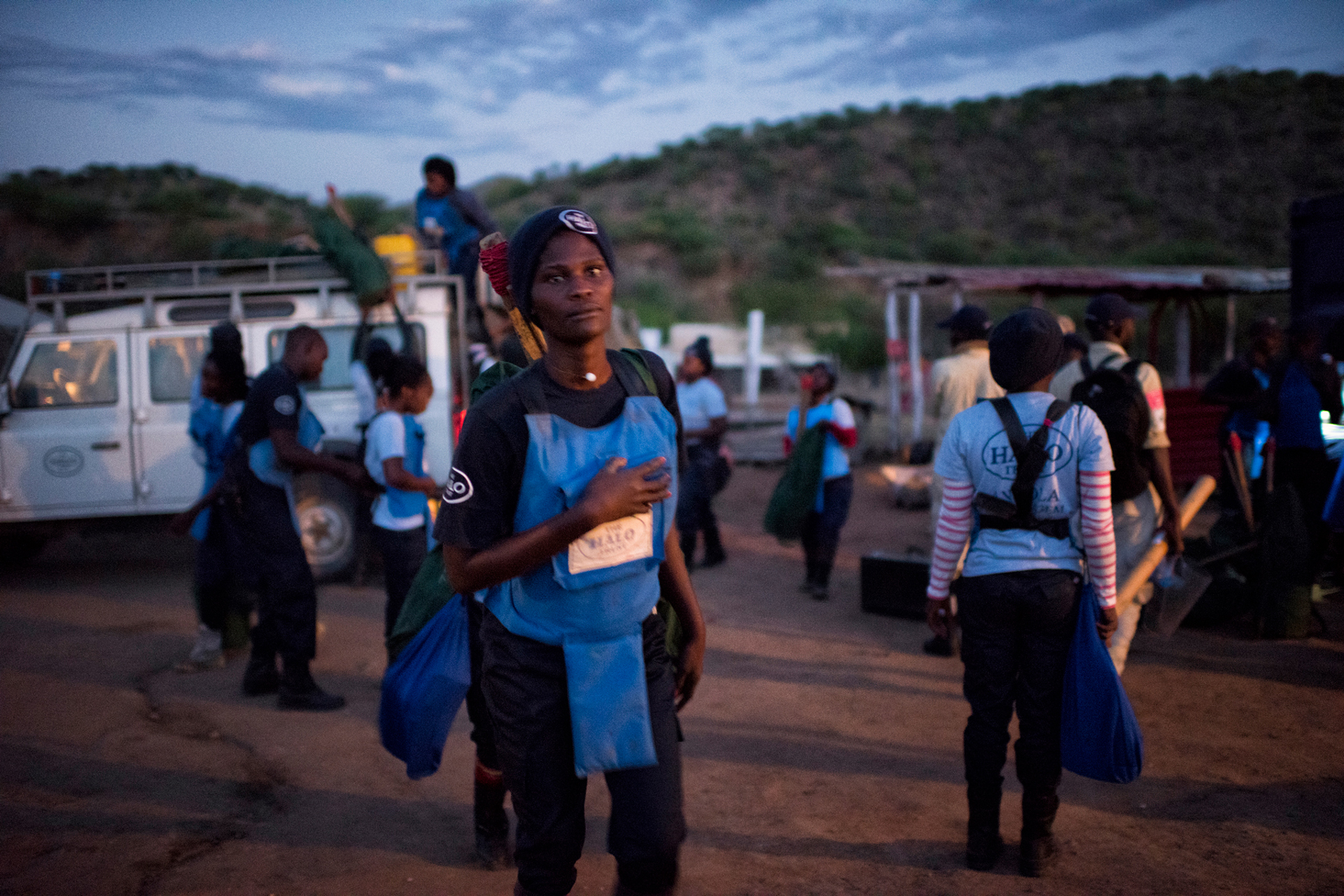 Women wearing PPE carry their bags in preparation