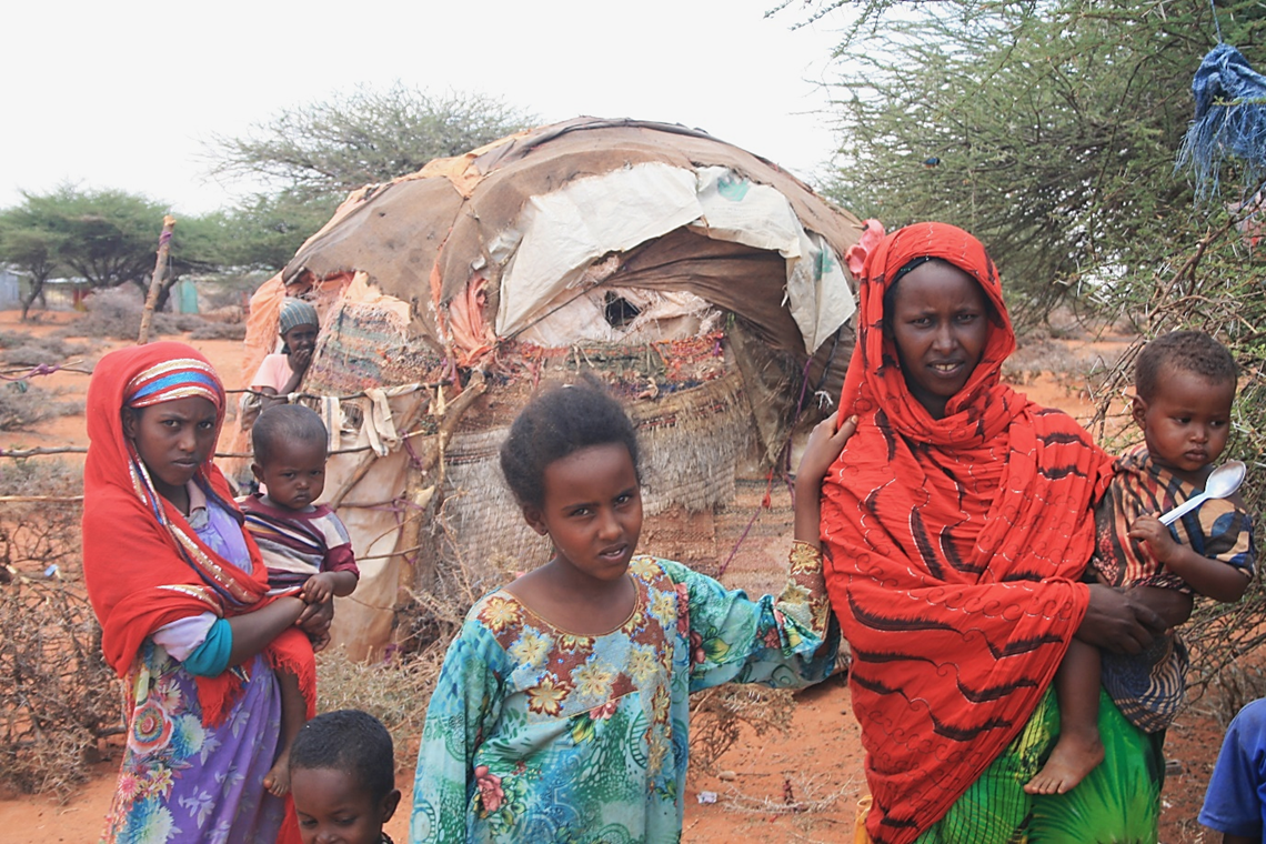 Nimco (right) outside her house with her children and some of her neighbours, all of whom live on top of a minefield