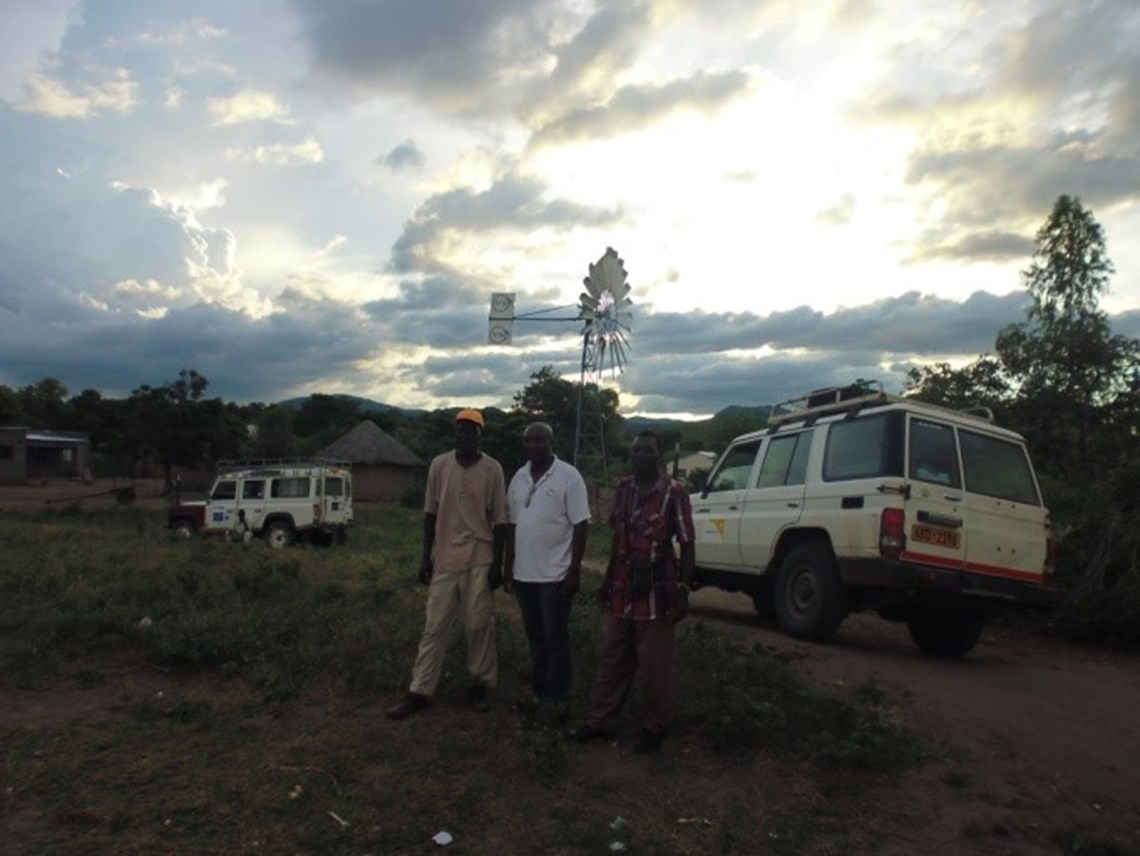 Bandimba and Mr Mupasu (WorldVision) by the windmill as dusk falls after the last day of work on the repairs, HALO Trust.