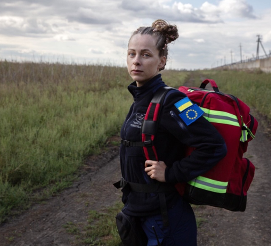 Olha Stotska, HALO's non-technical survey assistant, stands on a path in the middle of a field