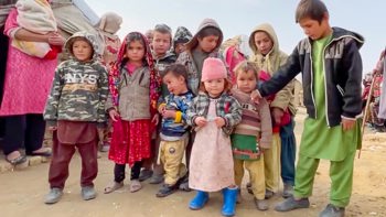 A group of children stand together in a refugee camp in Afghanistan