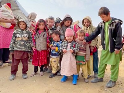 A group of children stand together in a refugee camp in Afghanistan