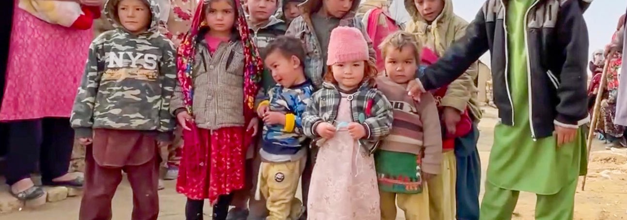A group of children stand together in a refugee camp in Afghanistan