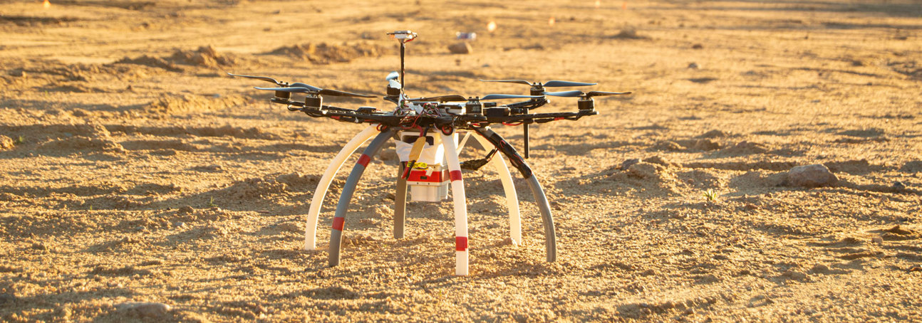 A drone used to identify mines and other explosive ordnance on the sandy soil of a minefield