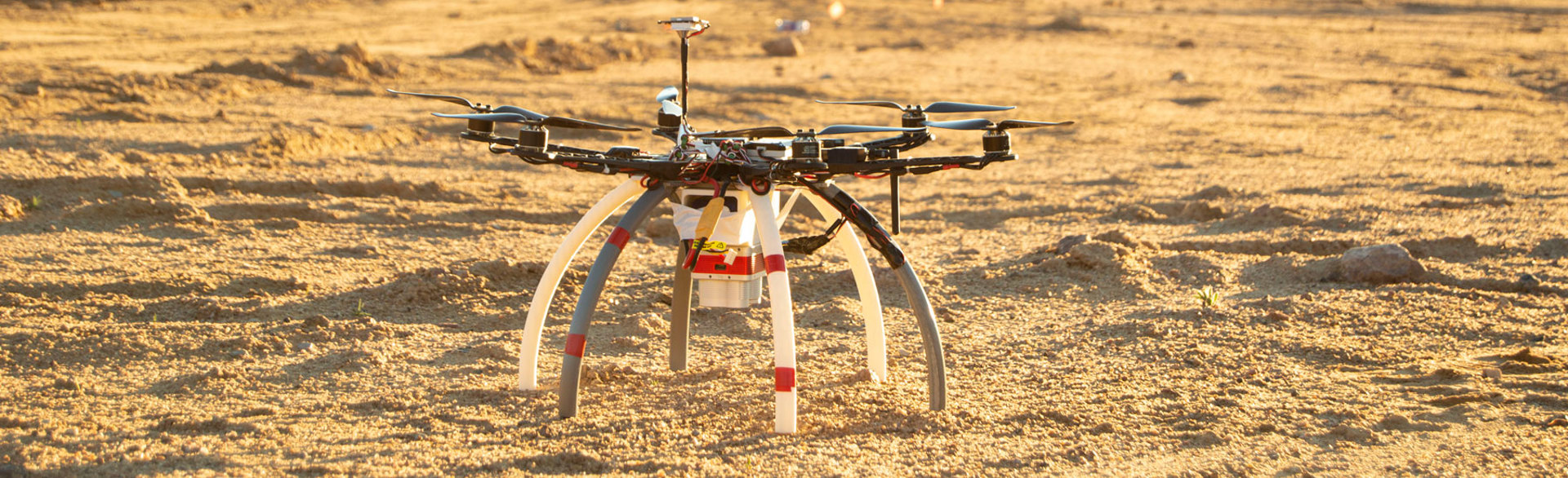 A drone used to identify mines and other explosive ordnance on the sandy soil of a minefield