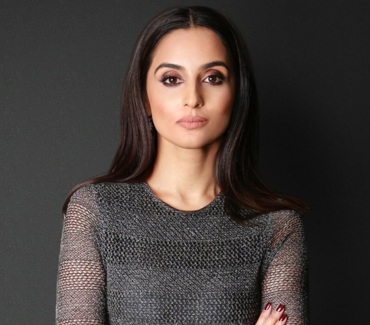 Headshot of a woman with long, dark hair wearing a grey dress