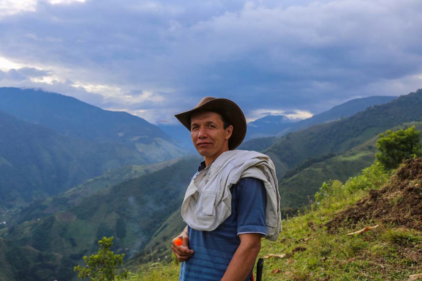 Eisenhower, a resident in El Cañón de Las Hermosas, stands before a scenic valley of nature in Colombia