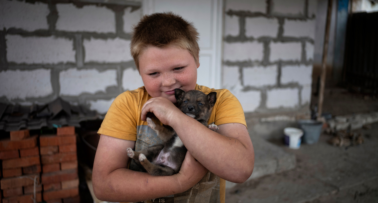 Син Мелехових біля дому обіймає цуценя