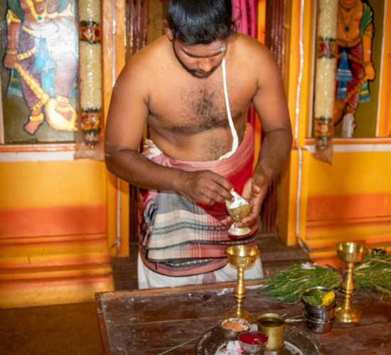 Nagathera Sharma, a priest, stands in a temple in Sri Lanka