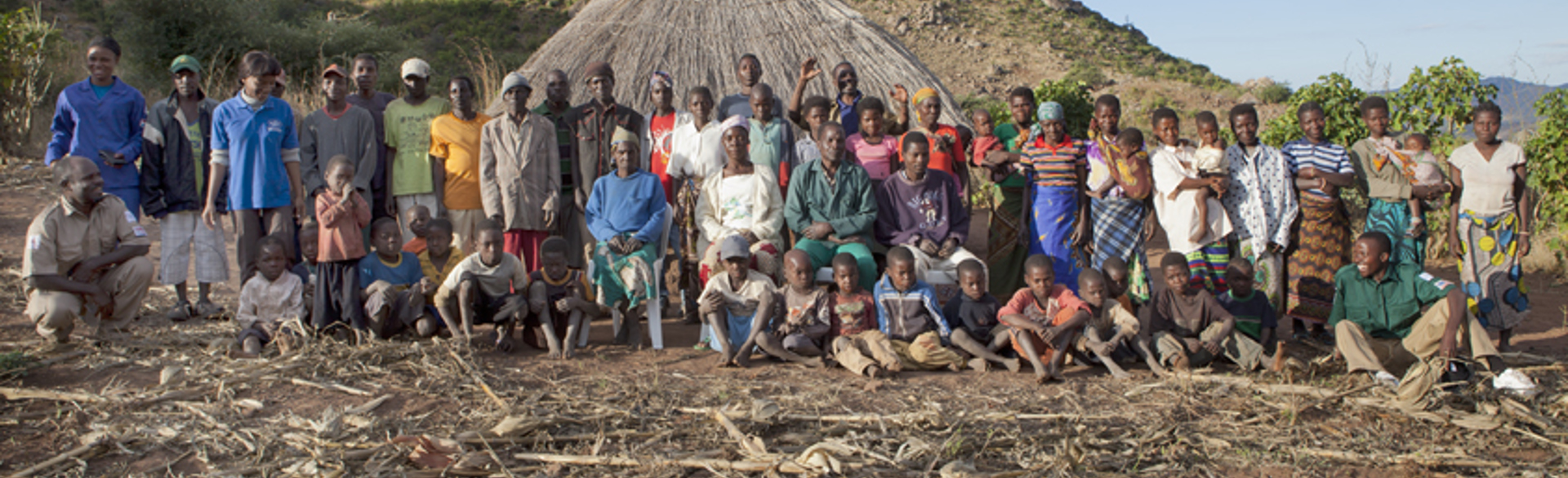 Group of people outside huts in Mozambique