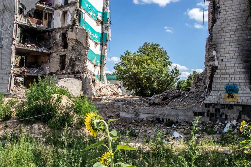 A collapsed building surrounded by sunflowers and plants in Borodyanka, Kyiv Region, Ukraine