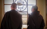 The head of the Franciscan Mission and a HALO Trust staff member stand and look out of the window of the recently cleared compound