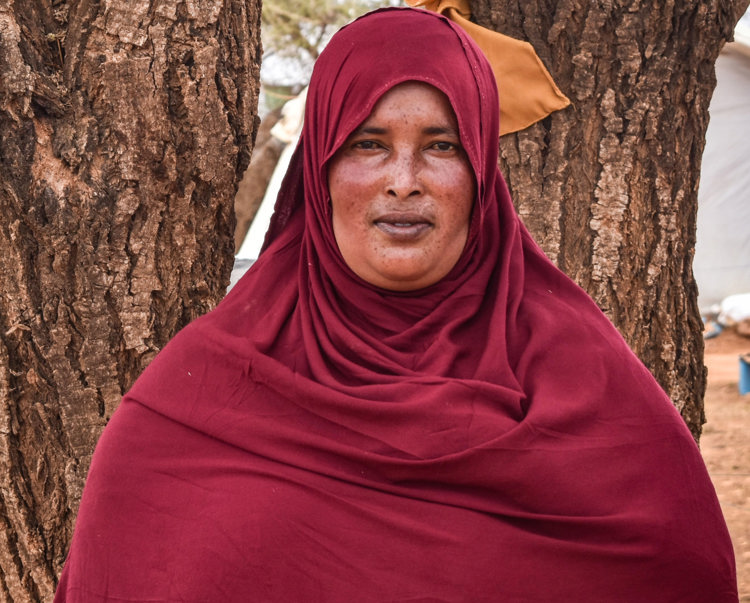 Samsam Mahamed Adan, stands in front of trees in Somaliland