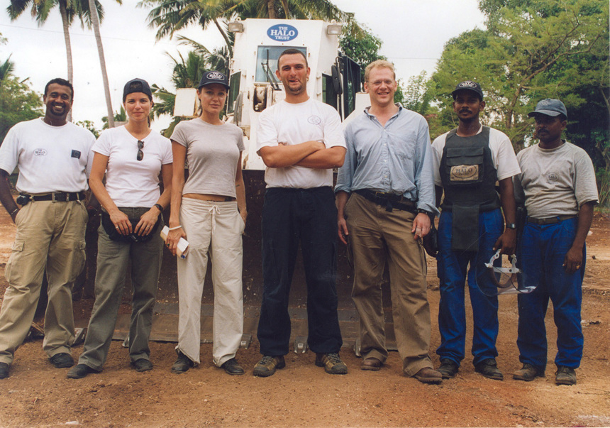 A group of HALO Staff stand in front of a mechanical asset in Sri Lanka in 2003