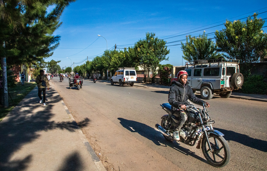 The same area today, now a bustling street known as Avenida 28 de Maio, where children safely attend school and the community thrives.