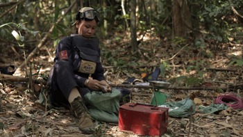A HALO deminer sits in the jungle with their demining equipment