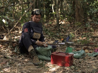 A HALO deminer sits in the jungle with their demining equipment