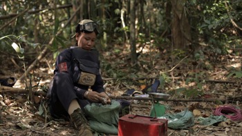 A HALO deminer sits in the jungle with their demining equipment
