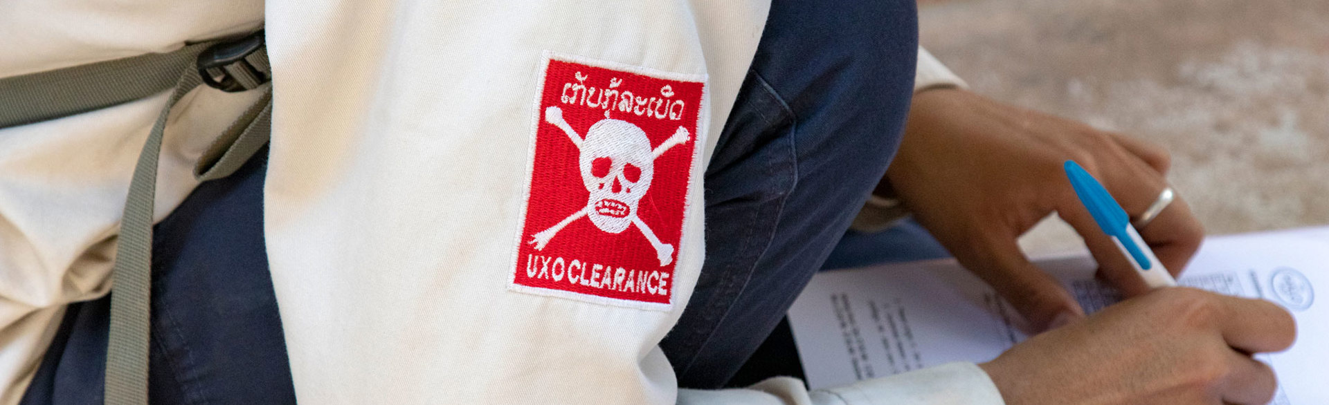 A member of a UXO clearance team fills out a checklist in Laos
