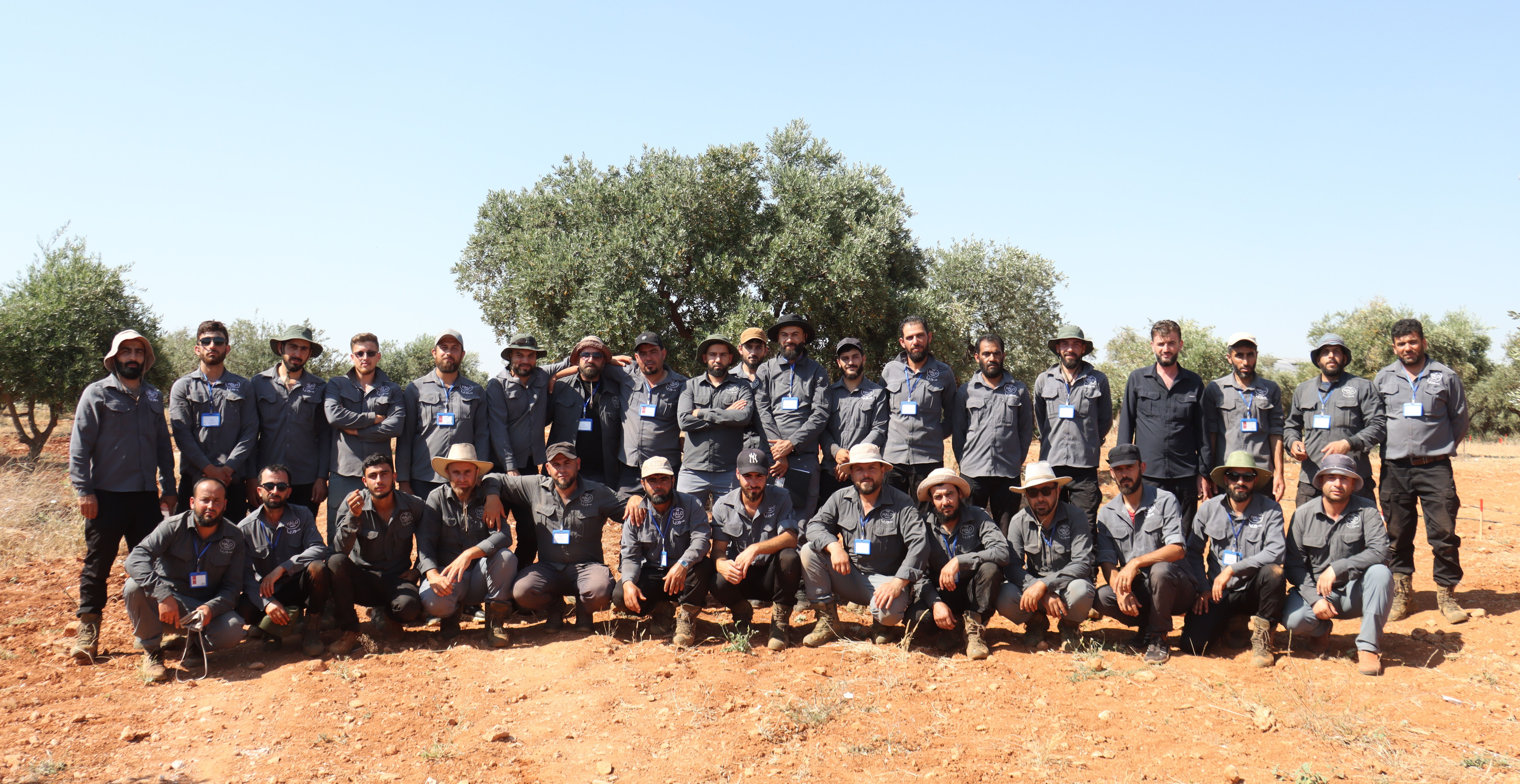 A large group of international HALO deminers with their Syrian counterparts pose for the camera in Idlib