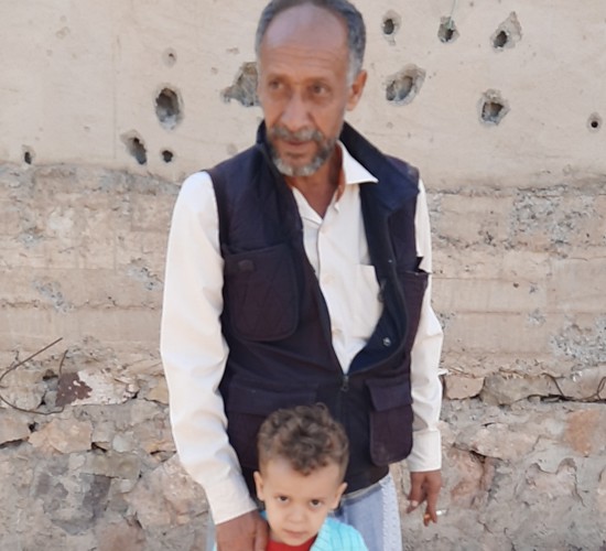 A man stands with a young child.