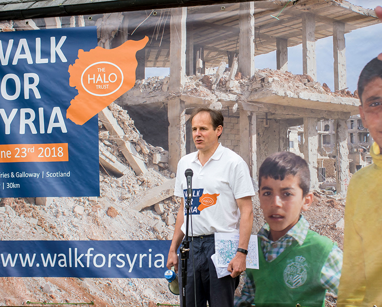 James Cowan stands behind a microphone as he gives a speech at the "walk for Syria" event