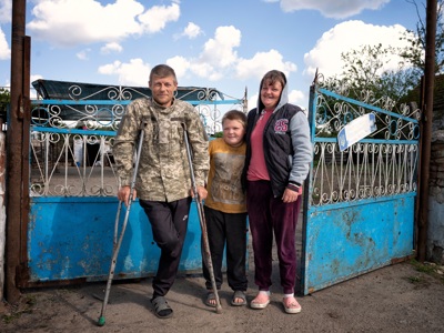 Родина Мелезових біля воріт дому