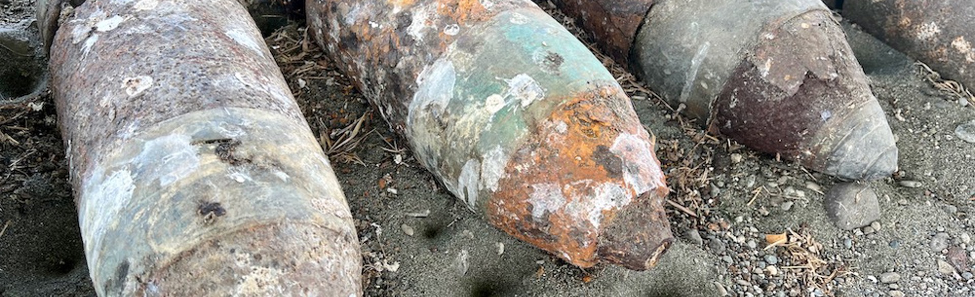 A collection of rusted US six-inch practice projectiles