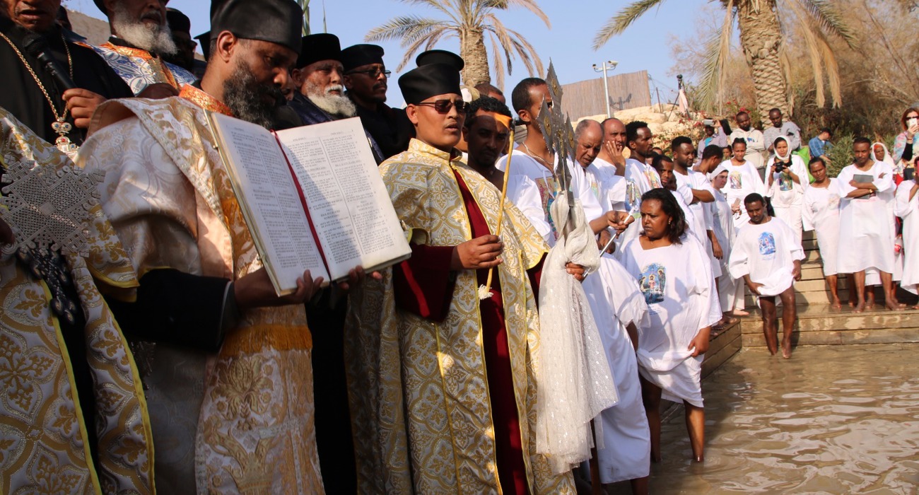Clergy lead a solemn procession during the epiphany service at the Baptism site, dressed in traditional robes.
