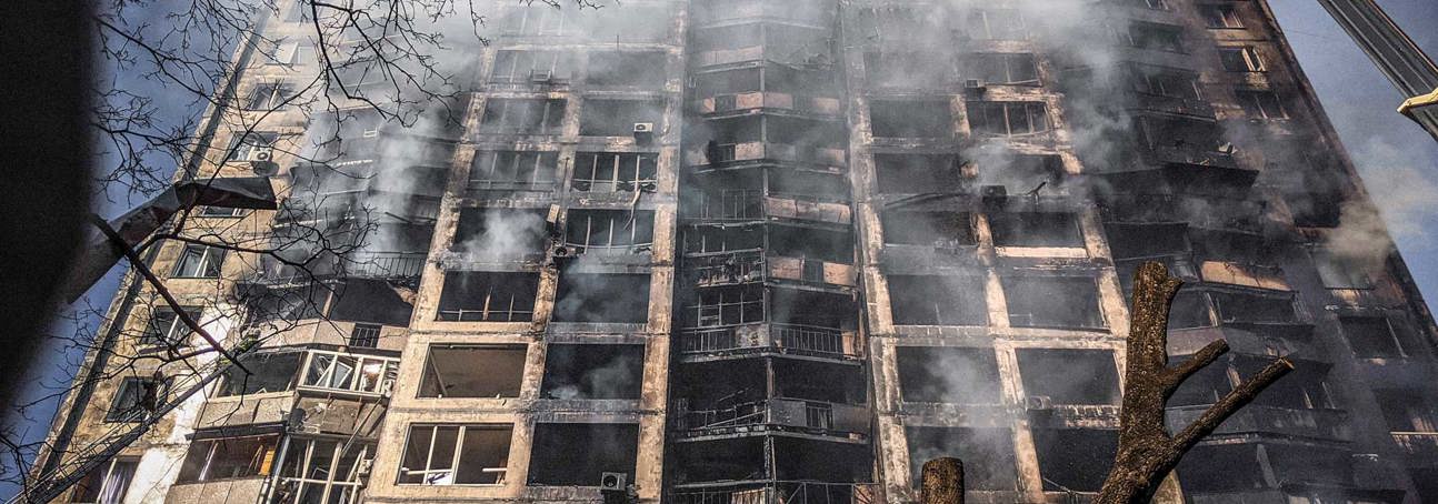 Smoke and flames being extinguished in a large apartment block in Ukraine