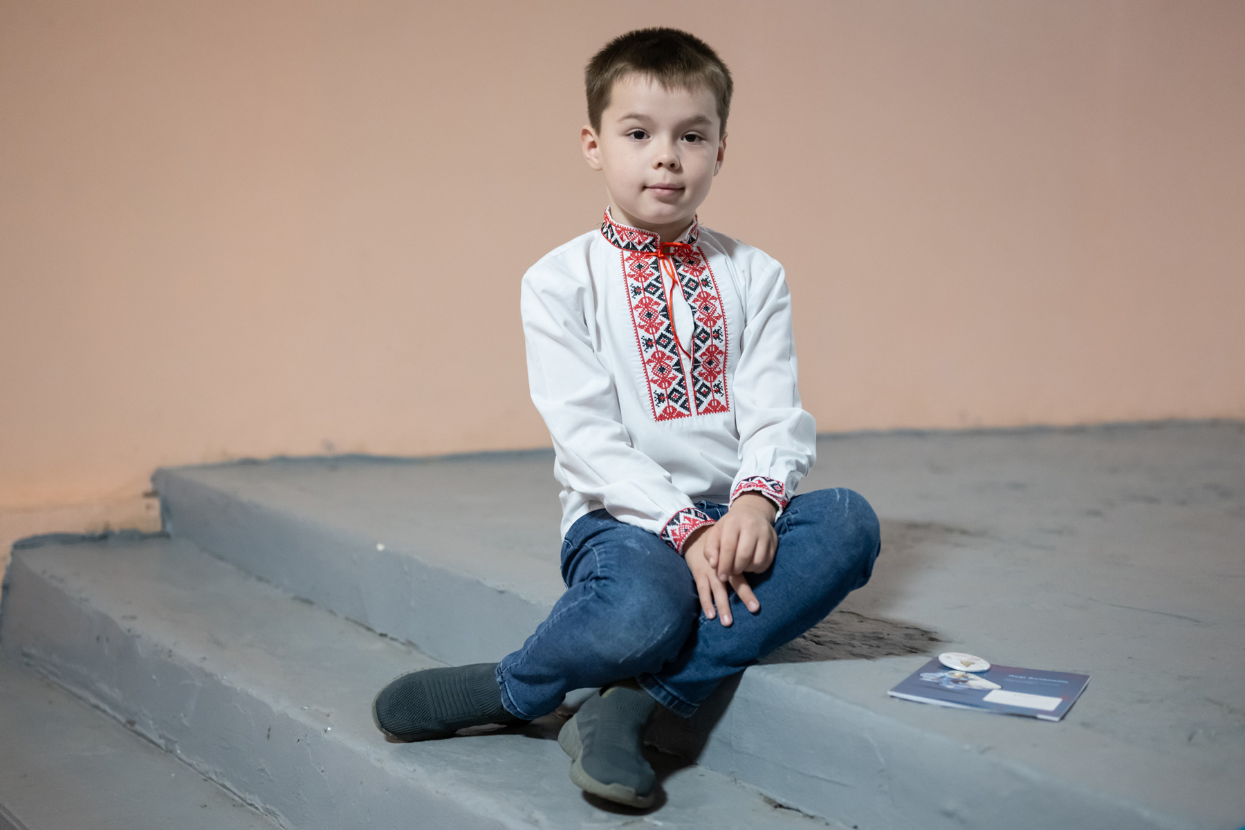 A young boy sits on a step in Ukraine