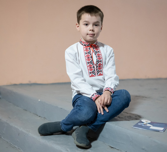 A young boy sits on a step in Ukraine