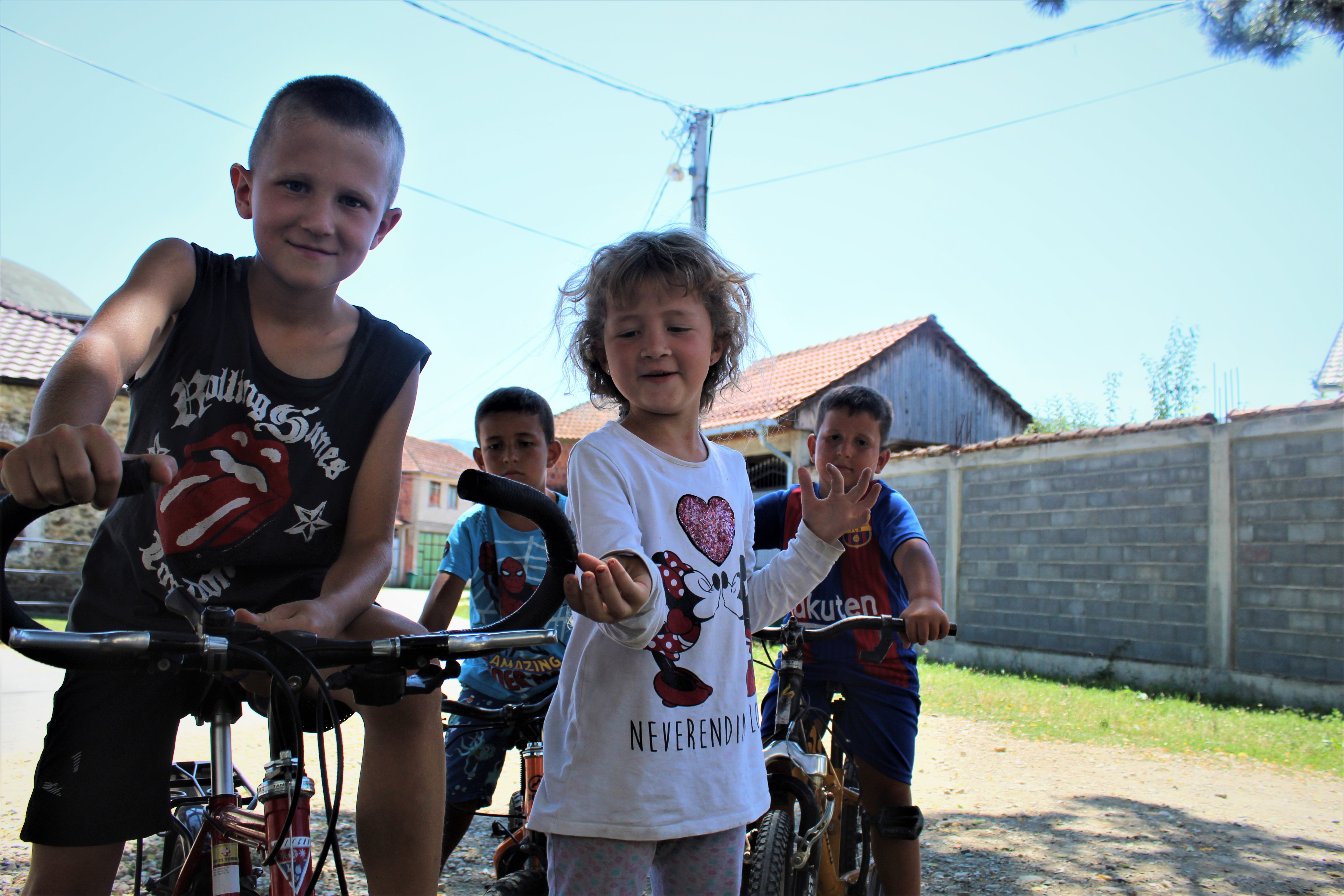 Siblings Bleart and Belinda riding their bikes with other small children behind them