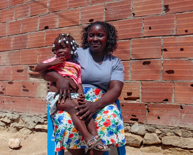 A woman sits posed with a child on her lap