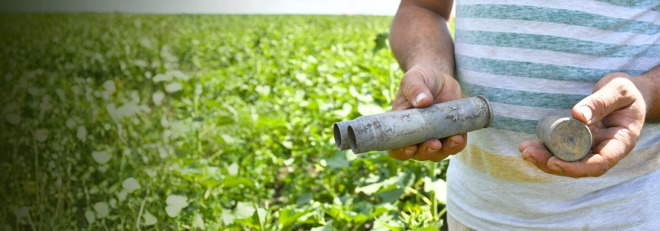 A close up shot of a man holding small, deactivated munitions.