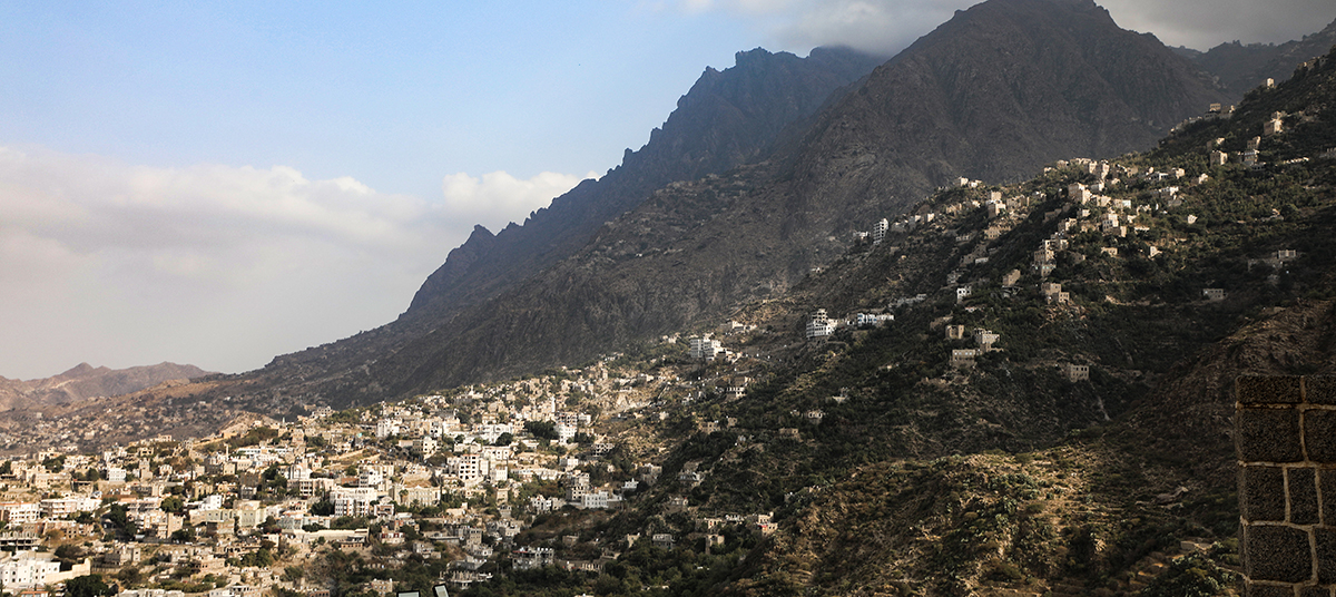 Buildings in a city creeping up the side of a large mountain