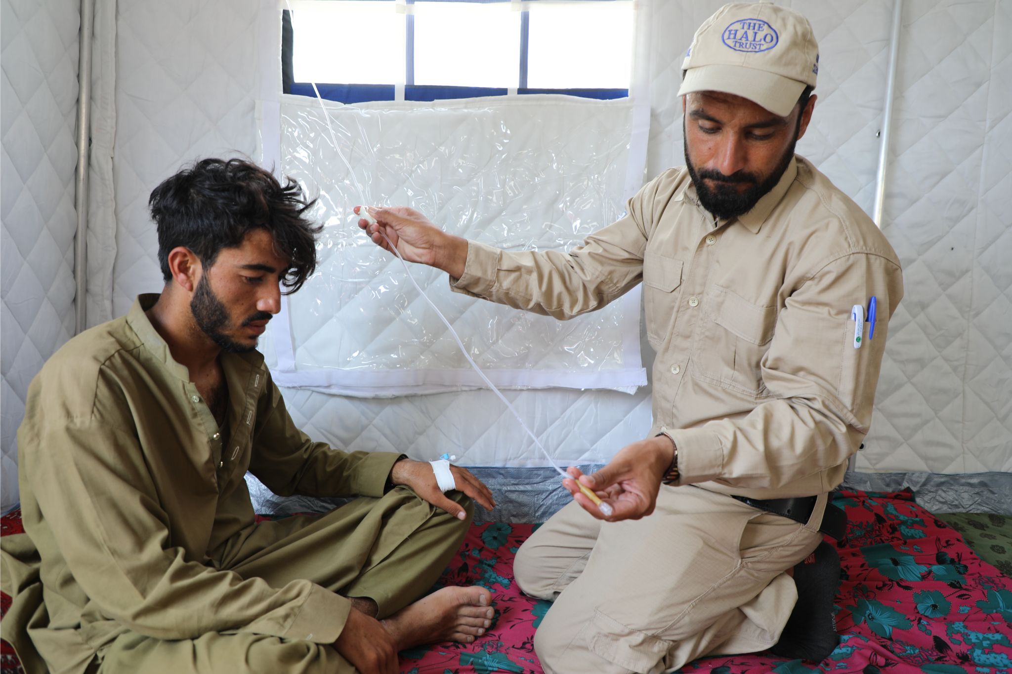 A HALO staffer providing emergency medical aid to a young man.