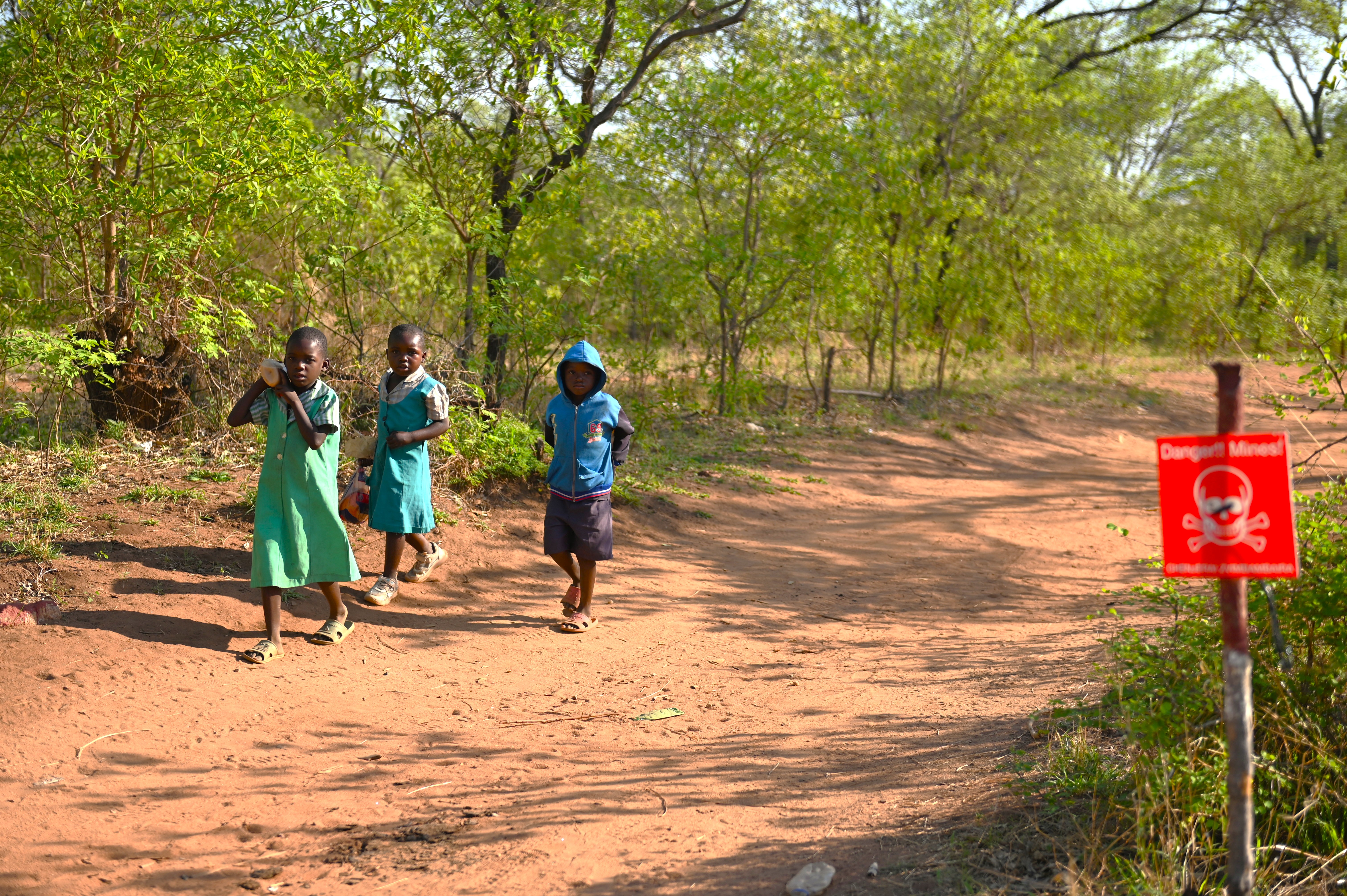 Children walking on the cleared side of a minefield