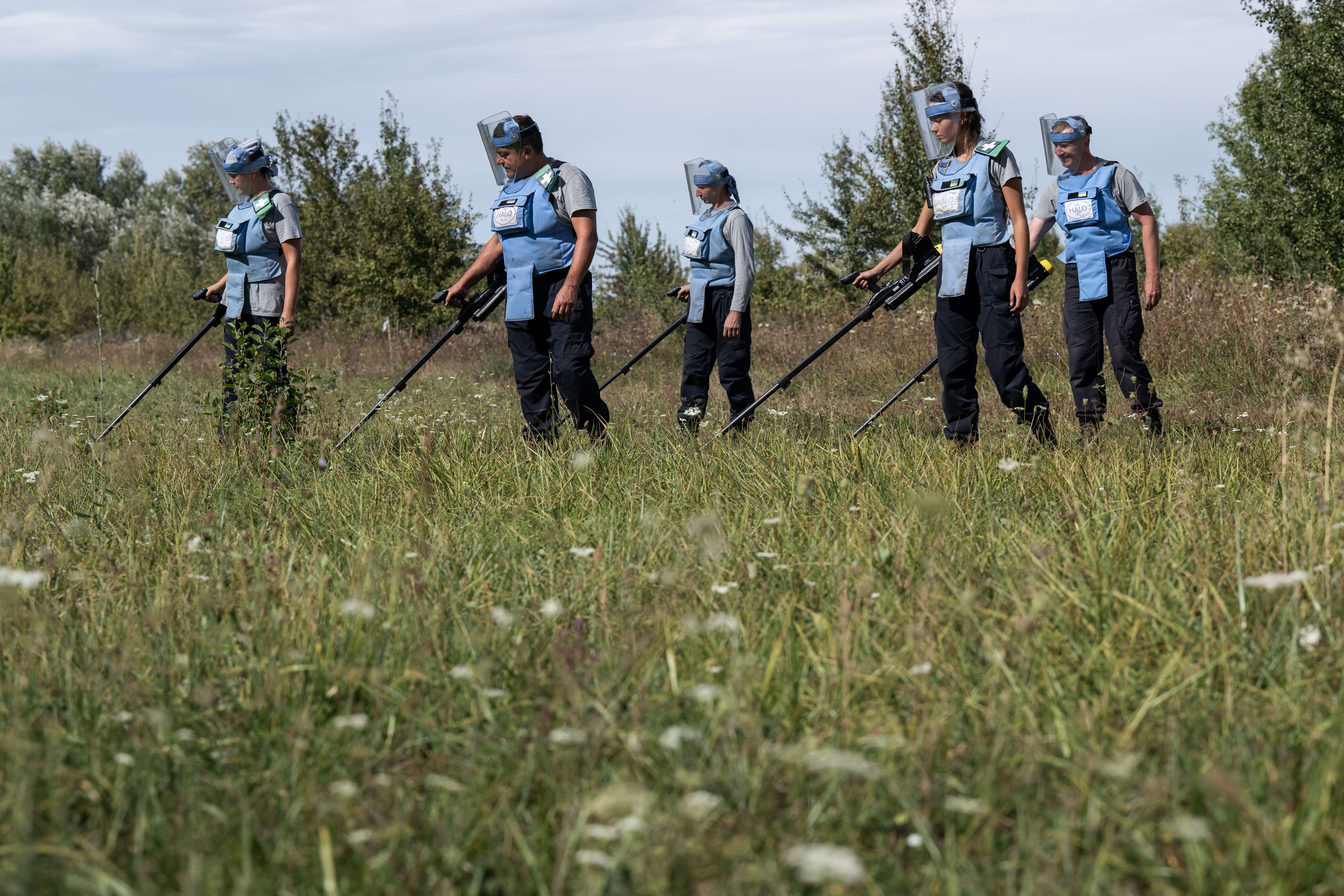 Група демінерів проводить пошук вибухонебезпечних предметів на поверхні грунту за допомогою детекторів