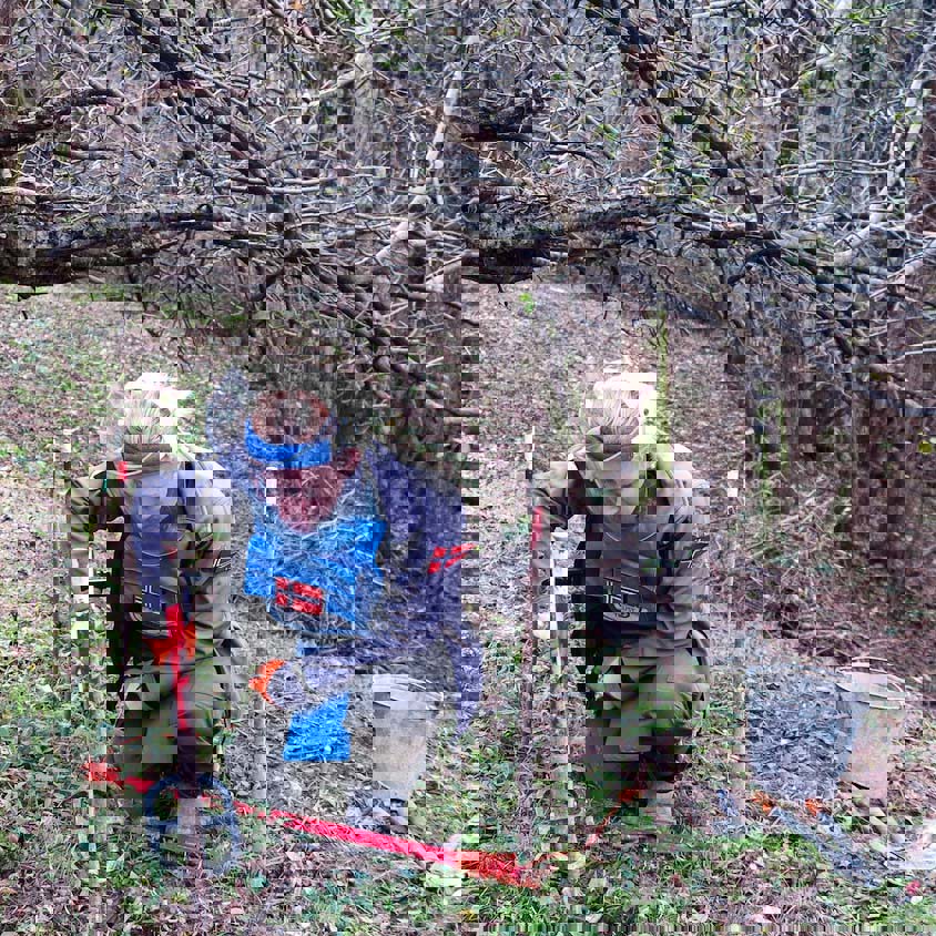 A deminer carefully uses a detector in woodland in Lindava village