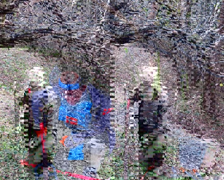 A deminer carefully uses a detector in woodland in Lindava village