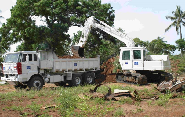 An armoured digger scoops rubble into the back of a lorry in Sri Lanka